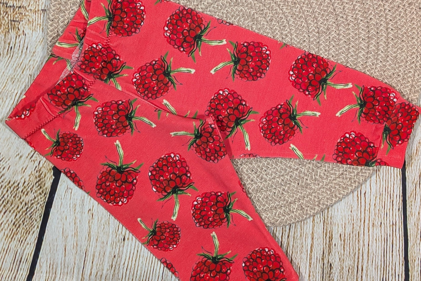 Red fabric with raspberry pattern on a wooden surface